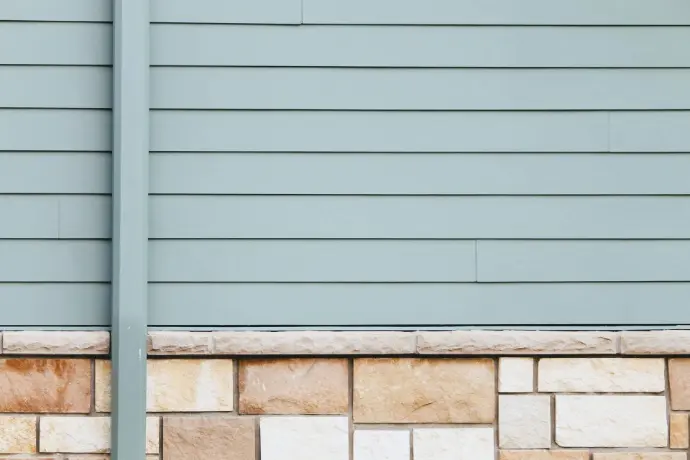 Close-up of fiber-cement lap siding over a stone wainscot, showcasing crisp reveals and moisture-managed transitions. Durable, low-maintenance exterior detailing installed by Apex Exteriors for Sierra climates from Tahoe to Sacramento.