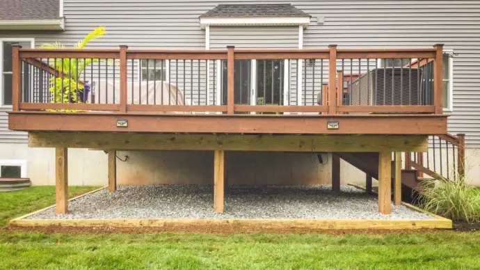 Engineered backyard deck with composite surface, black baluster rail, and gravel drainage bed for clean maintenance. Strong footings and treated framing deliver a stable, long-lasting space for dining and lounging in Placerville.