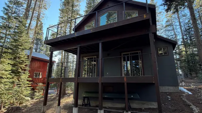 Two-level cabin deck with cable guardrails, reinforced posts, and composite surfacing. Designed for heavy weather and low upkeep while preserving sweeping forest views—premium outdoor living in Tahoe.